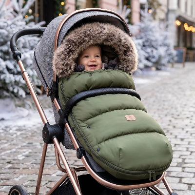 Chancelière poussette et bébé souriant dans une chancelière poussette chaude en hiver